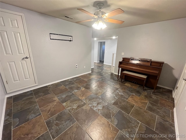 114227 S 4172nd Rd, Checotah, OK 74426 - living area featuring stone tile flooring, a ceiling fan, and baseboards
