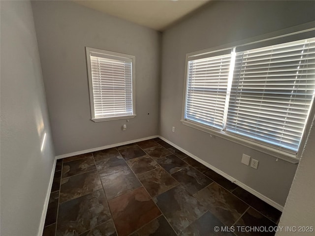 114227 S 4172nd Rd, Checotah, OK 74426 - unfurnished room featuring baseboards and dark stone finish floors