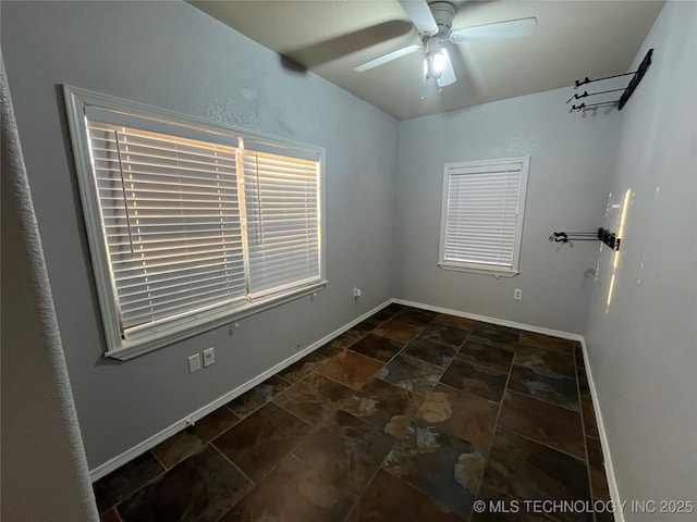 114227 S 4172nd Rd, Checotah, OK 74426 - empty room featuring dark stone finish floors, a ceiling fan, and baseboards