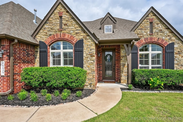 16425 E 49th St, Tulsa, OK 74134 - view of front of home featuring stone siding, roof with shingles, brick siding, and a front yard