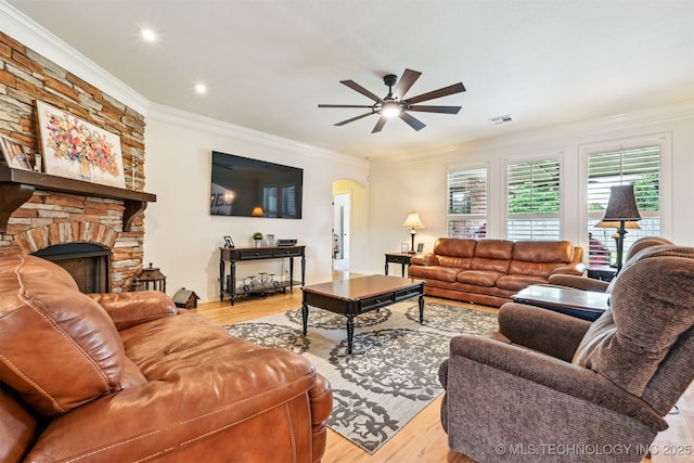 16425 E 49th St, Tulsa, OK 74134 - living area featuring a ceiling fan, wood finished floors, ornamental molding, arched walkways, and a stone fireplace