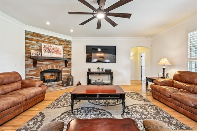 16425 E 49th St, Tulsa, OK 74134 - living area featuring ceiling fan, arched walkways, wood finished floors, crown molding, and a stone fireplace