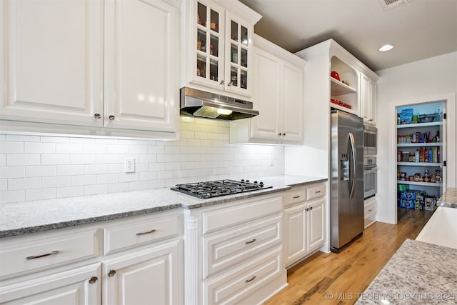 16425 E 49th St, Tulsa, OK 74134 - kitchen with appliances with stainless steel finishes, under cabinet range hood, white cabinetry, light wood-style flooring, and glass insert cabinets
