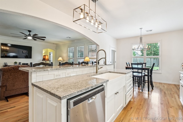 16425 E 49th St, Tulsa, OK 74134 - kitchen with stainless steel dishwasher, arched walkways, light wood finished floors, and plenty of natural light