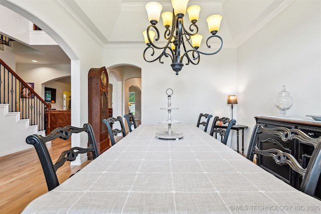 16425 E 49th St, Tulsa, OK 74134 - dining area featuring arched walkways, a chandelier, wood finished floors, ornamental molding, and stairs