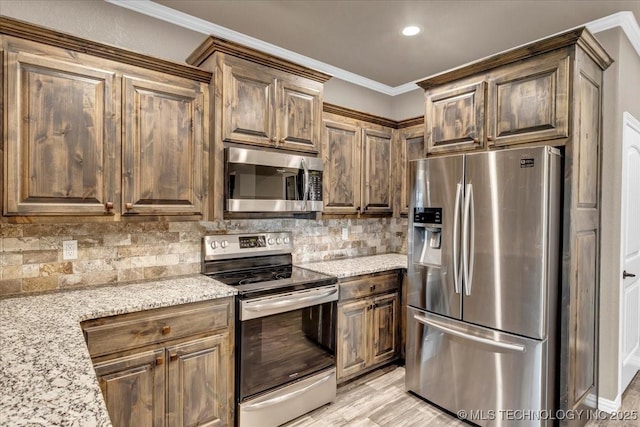 97 Paytons Pl, Durant, OK 74701 - kitchen with stainless steel appliances, crown molding, decorative backsplash, light stone counters, and light wood finished floors