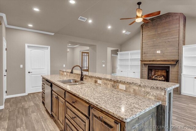 97 Paytons Pl, Durant, OK 74701 - kitchen featuring stainless steel dishwasher, a sink, a ceiling fan, a kitchen island with sink, and light wood finished floors
