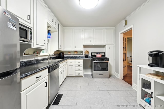 3510 E 21st Pl, Tulsa, OK 74114 - kitchen featuring appliances with stainless steel finishes, white cabinets, a sink, light tile patterned flooring, and dark stone countertops