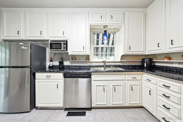 3510 E 21st Pl, Tulsa, OK 74114 - kitchen featuring stainless steel appliances, a sink, light tile patterned floors, and white cabinets