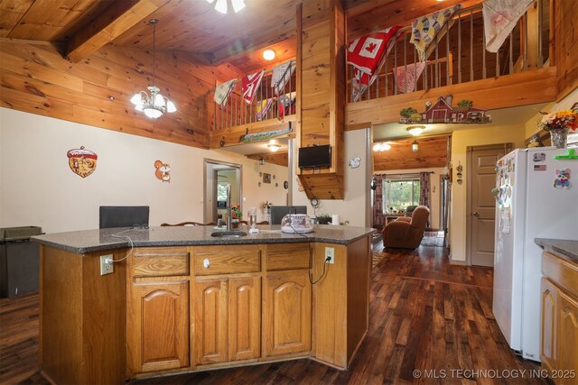 2984 Church Rd, Mead, OK 73449 - kitchen with freestanding refrigerator, dark wood-style floors, high vaulted ceiling, hanging light fixtures, and brown cabinets