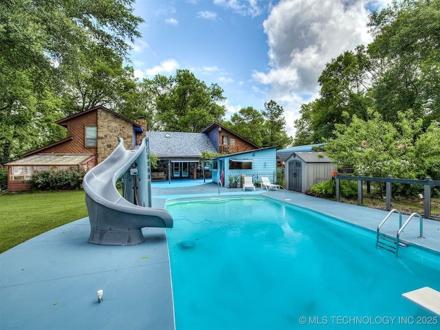 25206 E 64th St, Broken Arrow, OK 74012 - view of swimming pool with a water slide, a diving board, a patio, a lawn, and view of wooded area