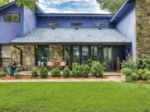25206 E 64th St, Broken Arrow, OK 74012 - back of property featuring a lawn, stone siding, and a shingled roof