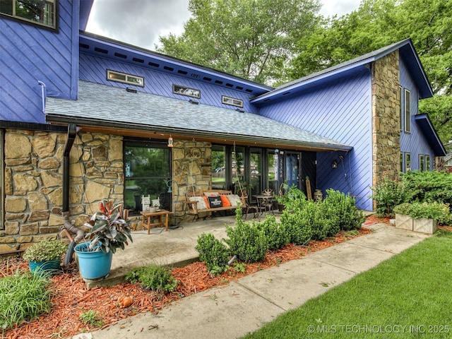 25206 E 64th St, Broken Arrow, OK 74012 - back of house with stone siding and roof with shingles