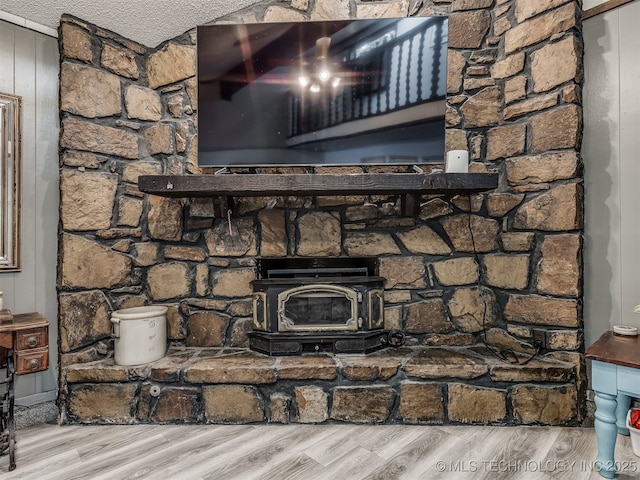 25206 E 64th St, Broken Arrow, OK 74012 - detailed view of wood finished floors, a wood stove, and a textured ceiling