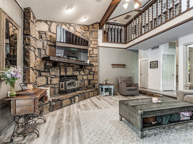 25206 E 64th St, Broken Arrow, OK 74012 - living area with a wood stove, wood finished floors, a textured ceiling, high vaulted ceiling, and ceiling fan
