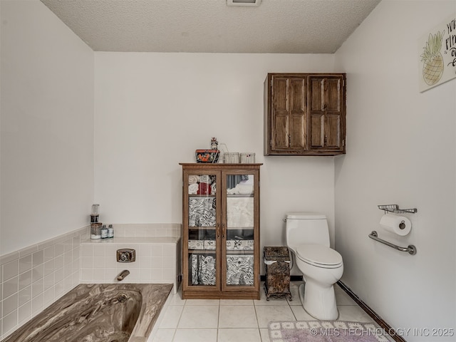 25206 E 64th St, Broken Arrow, OK 74012 - bathroom featuring a bath, toilet, tile patterned floors, and a textured ceiling