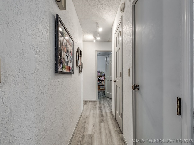 25206 E 64th St, Broken Arrow, OK 74012 - hall with a textured wall, a textured ceiling, and light wood finished floors