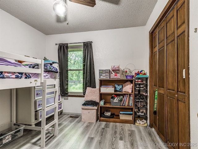 25206 E 64th St, Broken Arrow, OK 74012 - bedroom with wood finished floors, a textured ceiling, ceiling fan, and a closet
