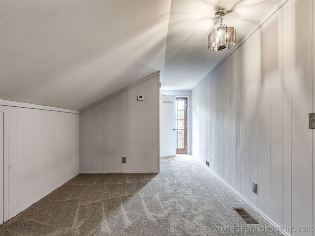 25206 E 64th St, Broken Arrow, OK 74012 - additional living space featuring carpet floors, a chandelier, lofted ceiling, and wood walls