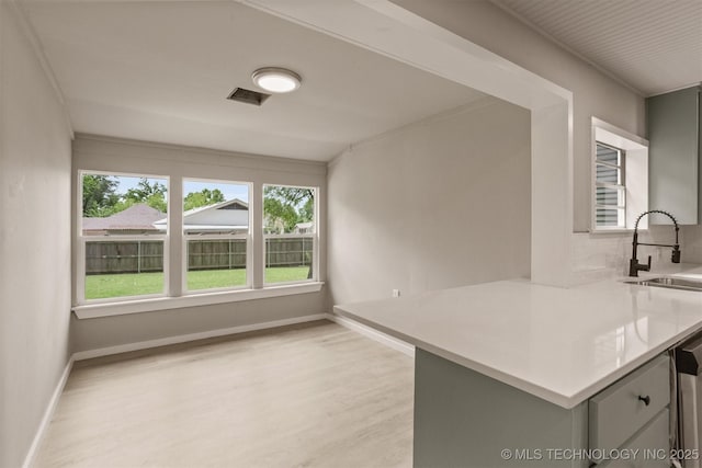 637 S Mounds St, Sapulpa, OK 74066 - kitchen featuring a sink, light wood finished floors, gray cabinets, and light countertops