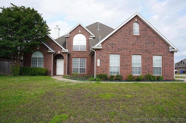 703 N Butternut Ct, Broken Arrow, OK 74012 - traditional-style home with brick siding, a chimney, and a front lawn