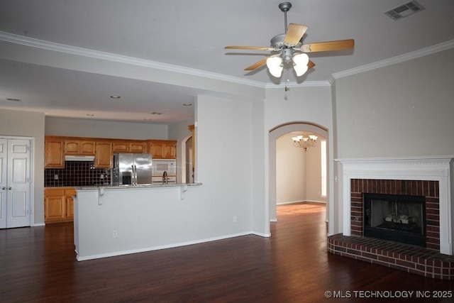 703 N Butternut Ct, Broken Arrow, OK 74012 - unfurnished living room with dark wood-style flooring, ceiling fan, a chandelier, arched walkways, and ornamental molding