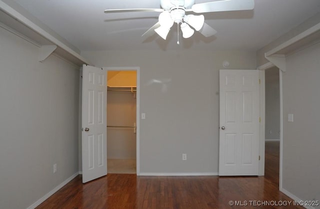 703 N Butternut Ct, Broken Arrow, OK 74012 - unfurnished bedroom featuring wood finished floors, a spacious closet, a closet, baseboards, and ceiling fan