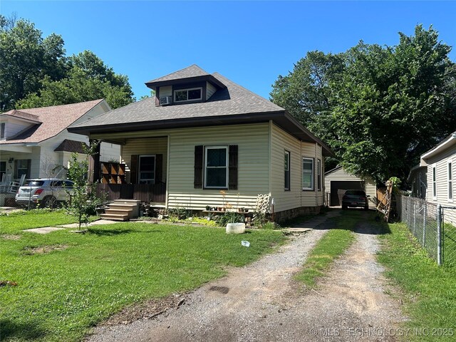1611 Baltimore St, Muskogee, OK 74403 - view of front of property featuring covered porch, driveway, an outbuilding, a shingled roof, and a garage