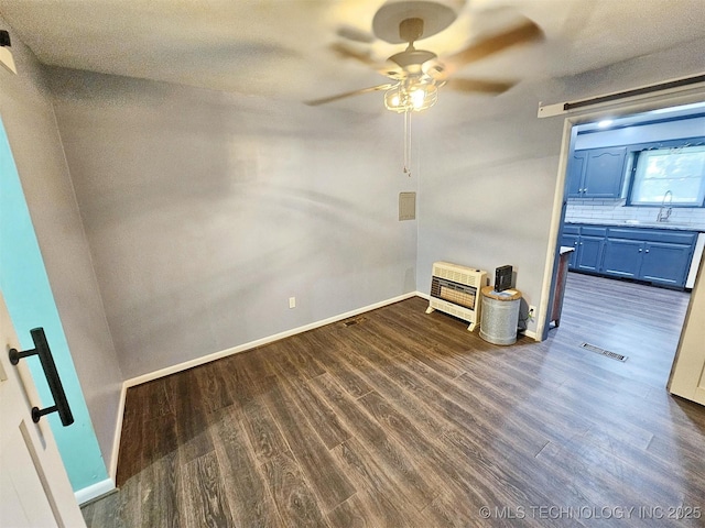 1306 E Shawnee St, Tahlequah, OK 74464 - empty room with heating unit, ceiling fan, and dark wood finished floors