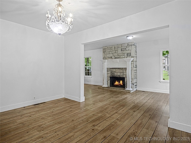 148 W 4th, Atoka, OK 74525 - unfurnished living room featuring hardwood / wood-style floors, a chandelier, a fireplace, and baseboards