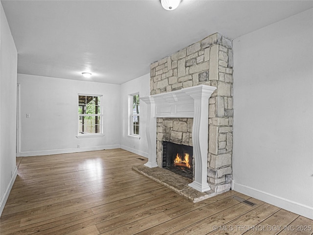 148 W 4th, Atoka, OK 74525 - unfurnished living room with a fireplace, hardwood / wood-style flooring, and baseboards