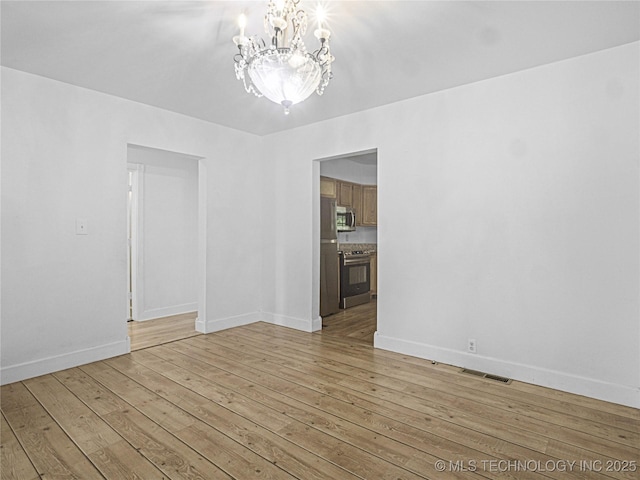 148 W 4th, Atoka, OK 74525 - empty room featuring a chandelier, light wood-type flooring, and baseboards