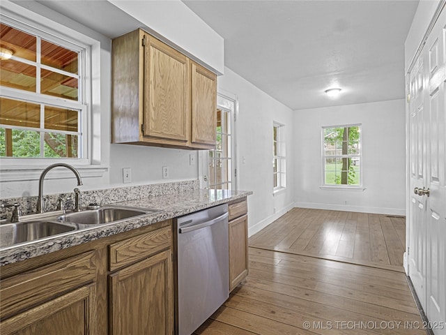 148 W 4th, Atoka, OK 74525 - kitchen featuring stainless steel dishwasher, a sink, light wood finished floors, baseboards, and light stone countertops