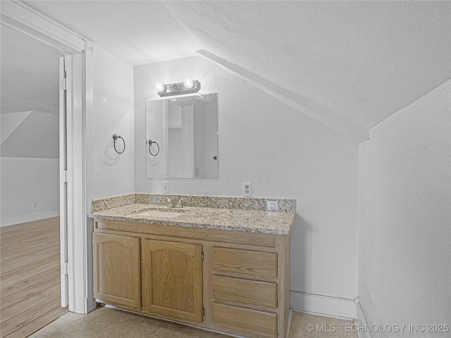 148 W 4th, Atoka, OK 74525 - bathroom featuring lofted ceiling, vanity, and a textured ceiling