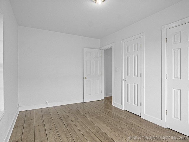 148 W 4th, Atoka, OK 74525 - unfurnished bedroom featuring hardwood / wood-style flooring and baseboards