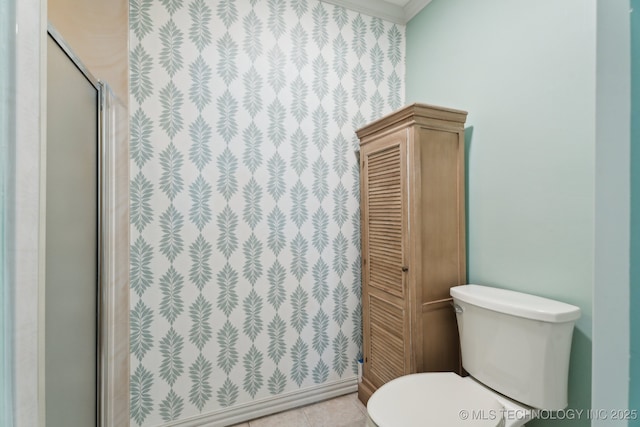 full bath with toilet, a stall shower, crown molding, and tile patterned floors