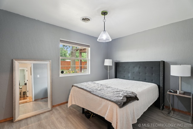 bedroom featuring wood finished floors and baseboards