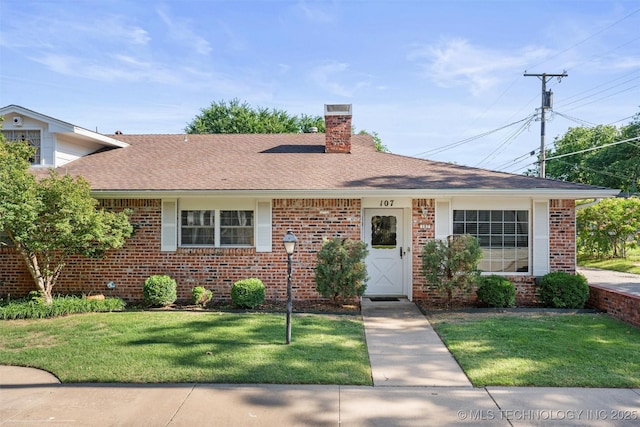 107 W 12th St Unit 107, Bartlesville, OK 74003 - view of front of property with a chimney, brick siding, a front lawn, and roof with shingles