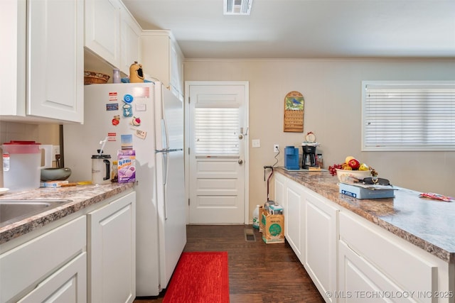 107 W 12th St Unit 107, Bartlesville, OK 74003 - kitchen featuring freestanding refrigerator, white cabinets, dark wood finished floors, light countertops, and ornamental molding