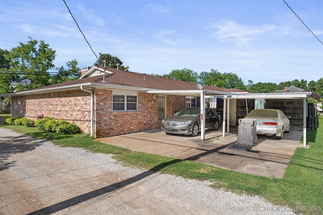 107 W 12th St Unit 107, Bartlesville, OK 74003 - view of side of home featuring brick siding, a detached carport, and driveway