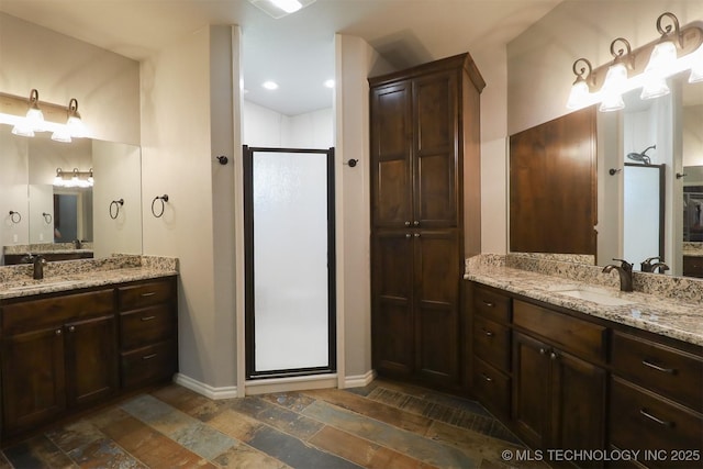 17061 S Creekwood Trl, Claremore, OK 74017 - full bath featuring a shower stall, baseboards, two vanities, stone finish floors, and a closet