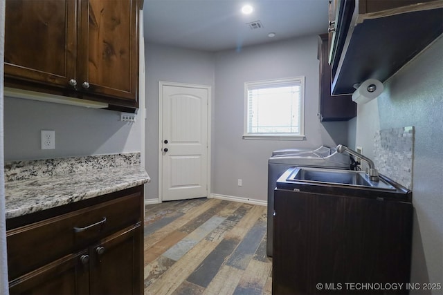 17061 S Creekwood Trl, Claremore, OK 74017 - kitchen featuring wood finished floors, dark brown cabinetry, a sink, and baseboards