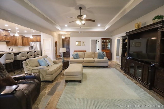 17061 S Creekwood Trl, Claremore, OK 74017 - living area featuring a tray ceiling, a ceiling fan, light wood finished floors, recessed lighting, and ornamental molding