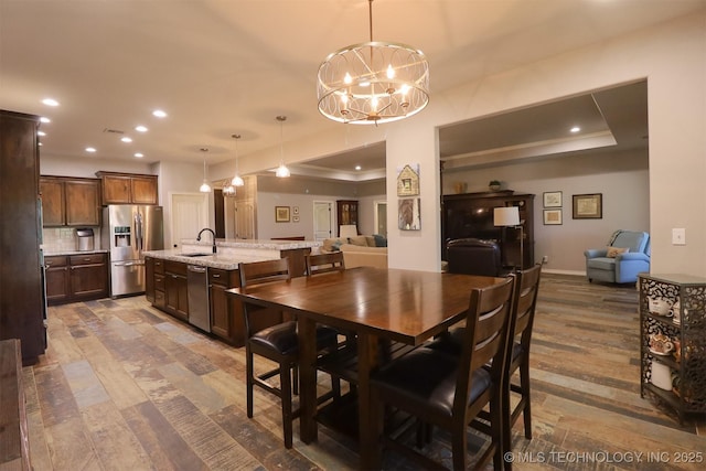 17061 S Creekwood Trl, Claremore, OK 74017 - dining space with a chandelier, a tray ceiling, recessed lighting, wood finished floors, and baseboards