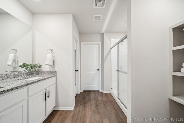 3324 N 23rd W Ave, Tulsa, OK 74127 - full bath featuring wood finished floors, a shower stall, vanity, and baseboards