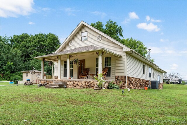 616 S Schlegel, Cushing, OK 74023 - view of front of property featuring covered porch, central AC, stone siding, and a front yard