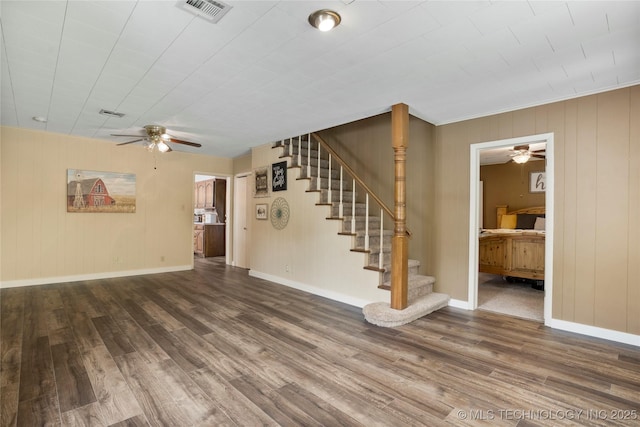 616 S Schlegel, Cushing, OK 74023 - unfurnished living room with ceiling fan, wood finished floors, stairs, baseboards, and wood walls