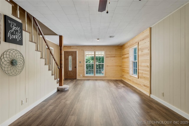 616 S Schlegel, Cushing, OK 74023 - unfurnished living room with dark wood finished floors, wood walls, baseboards, stairway, and a ceiling fan