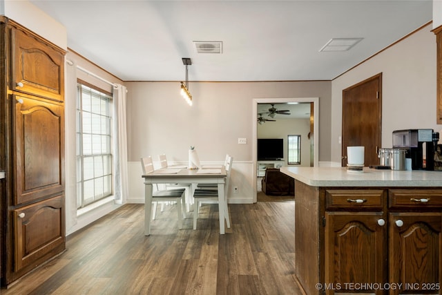 616 S Schlegel, Cushing, OK 74023 - kitchen featuring a ceiling fan, light countertops, dark wood-type flooring, plenty of natural light, and crown molding