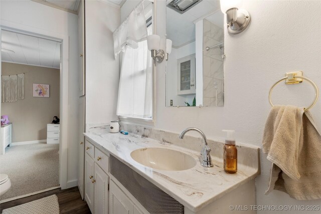 616 S Schlegel, Cushing, OK 74023 - bathroom with vanity, toilet, wood finished floors, and ornamental molding